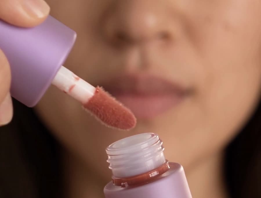 Close-up of a lip gloss being applied